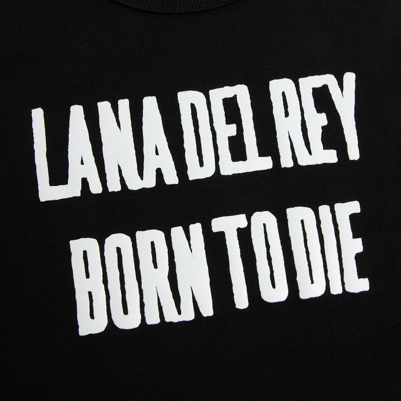 Close-up detail of the Born to Die Black Cropped Ribbed Tank Top showcasing the bold white LANA DEL REY BORN TO DIE graphic print on black ribbed fabric inspired by the classic Born to Die album merchandise.