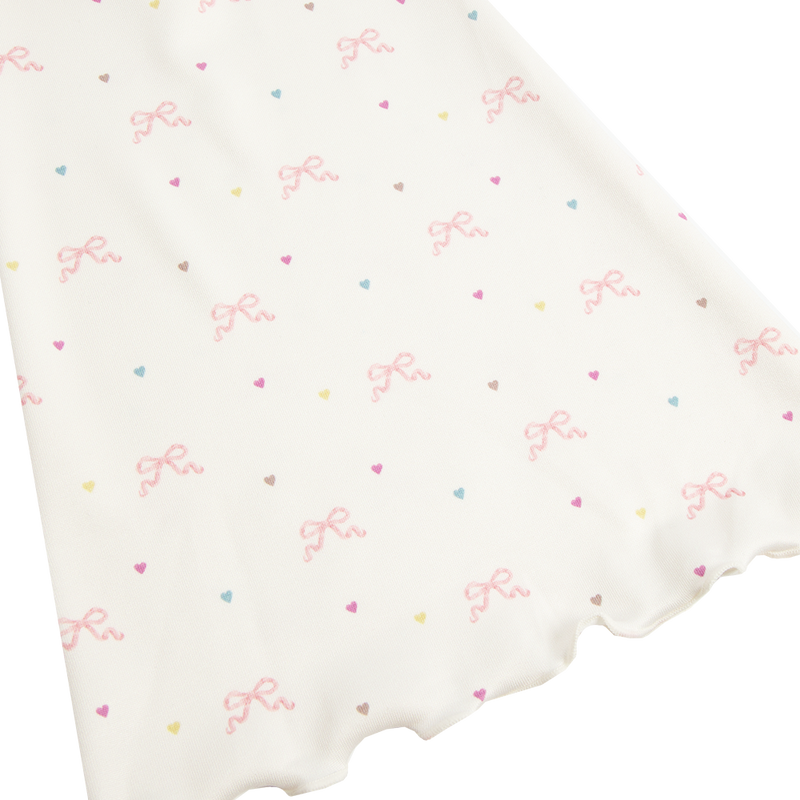 Close-up detail of the Bow Print Bolero Top showcasing the ivory fabric printed with delicate pink ribbon bows and pastel heart motifs, highlighting the soft romantic Lana Del Rey-inspired pattern.