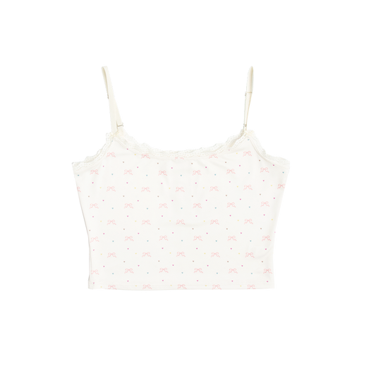 Front view of the Bow Print Cropped Cami Tank Top featuring an ivory cropped camisole with adjustable spaghetti straps, delicate lace trim, and an all-over pink ribbon bow and pastel heart print inspired by Lana Del Rey's romantic aesthetic.