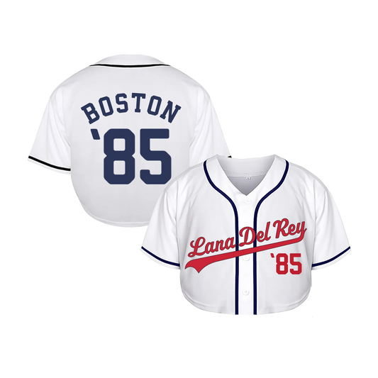 Front view of the Lana Del Rey Fenway Park Cropped Baseball Jersey in white featuring red script Lana Del Rey lettering, navy piping, button-up baseball design, cropped fit, and official Boston Fenway Park '85 concert merchandise.