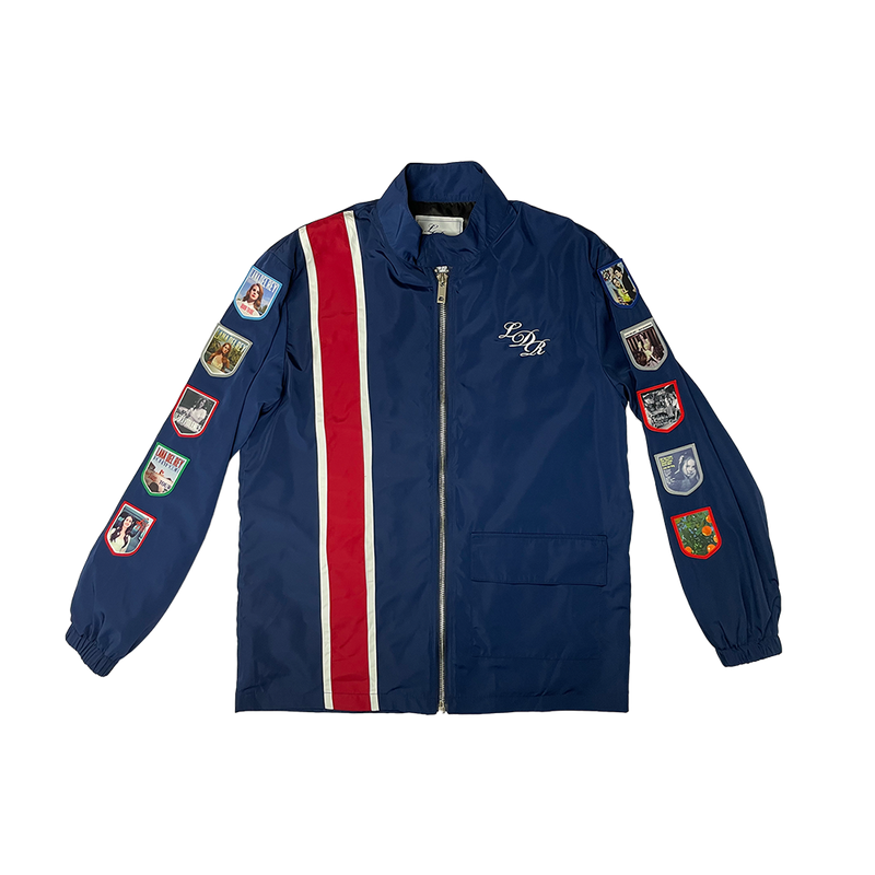 Front view of the Lana Del Rey Navy Album Patch Racing Jacket featuring embroidered LDR monogram, red and white racing stripes, and collectible album-inspired patches on both sleeves with a full-zip vintage motorsport design.