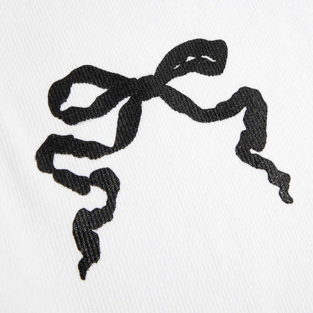 Close-up detail of the Lana Del Rey White Ribbed Print Tank Top showcasing the black ribbon bow graphic printed on white ribbed fabric with a textured finish.
